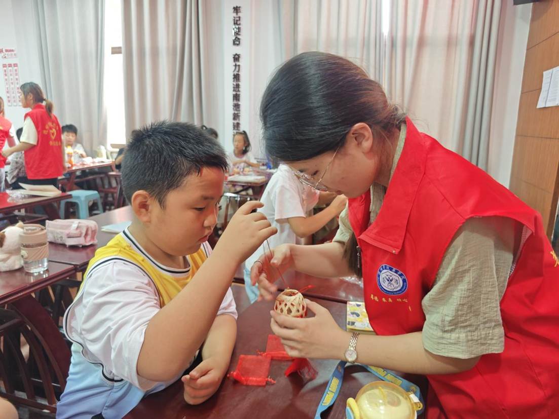 9.图为志愿者与青少年一起制作艾草驱蚊竹笼。张佳颖 供图