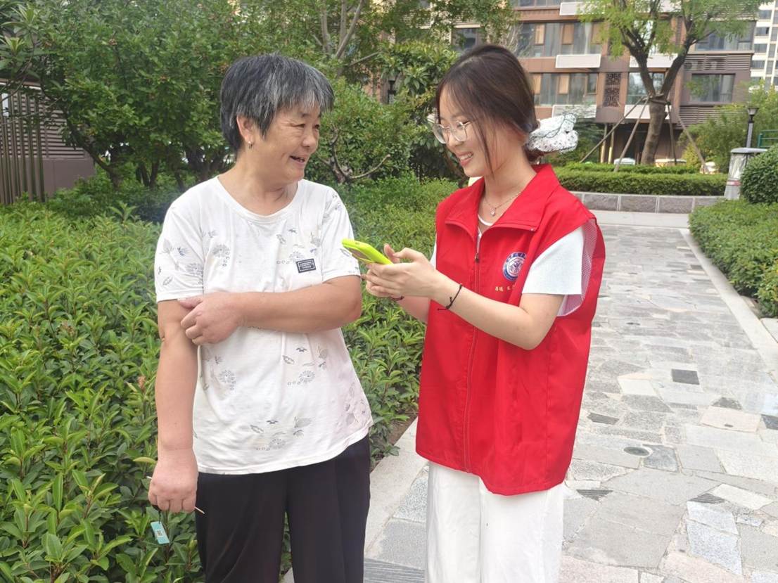 5.图为志愿者为社区区民科普智能手机如何网上预约挂号